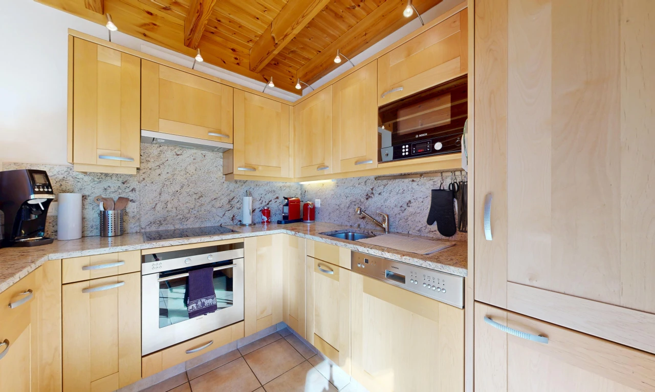 kitchen featuring light wood finish cabinets, black appliances, light stone counters, light tile patterned floors, and a wood ceiling with exposed beams