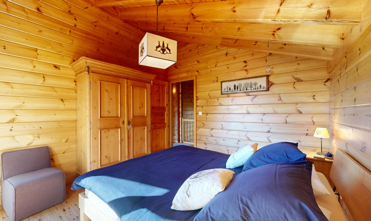 room / bedroom with wooden ceiling, lofted ceiling with beams, light wood finished floors, and wooden walls