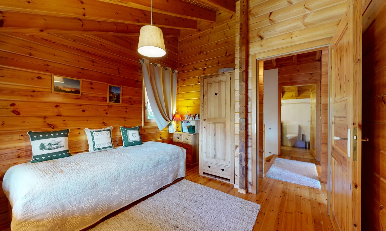 room with wood walls, hanging light fixtures, and light wood-type flooring