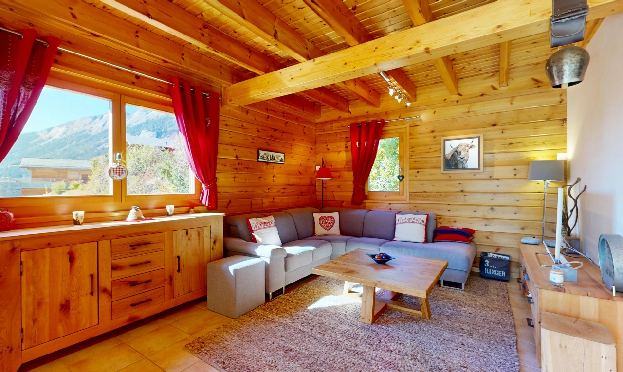 living area with wooden walls, a mountain view, a wooden ceiling with exposed beams, and light tile patterned floors