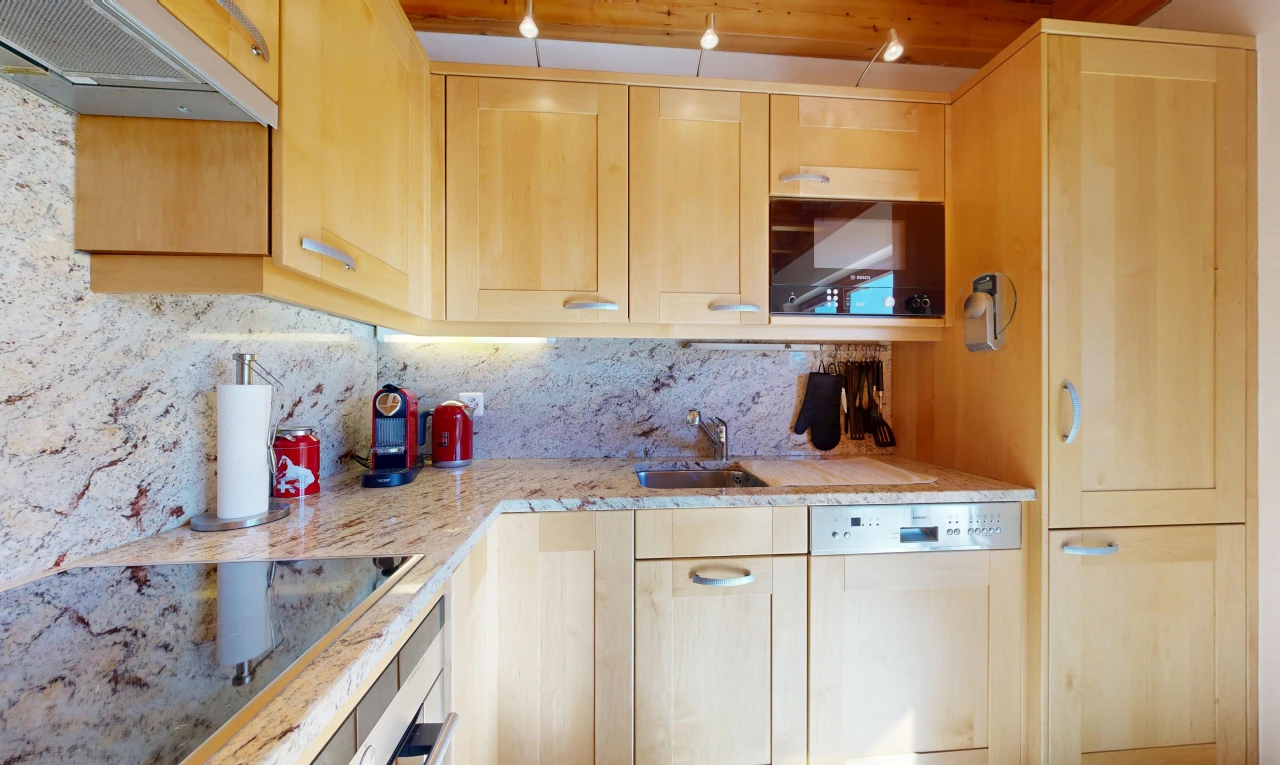 kitchen featuring light wood finish cabinets, black electric cooktop, light stone counters, white dishwasher, and wall oven
