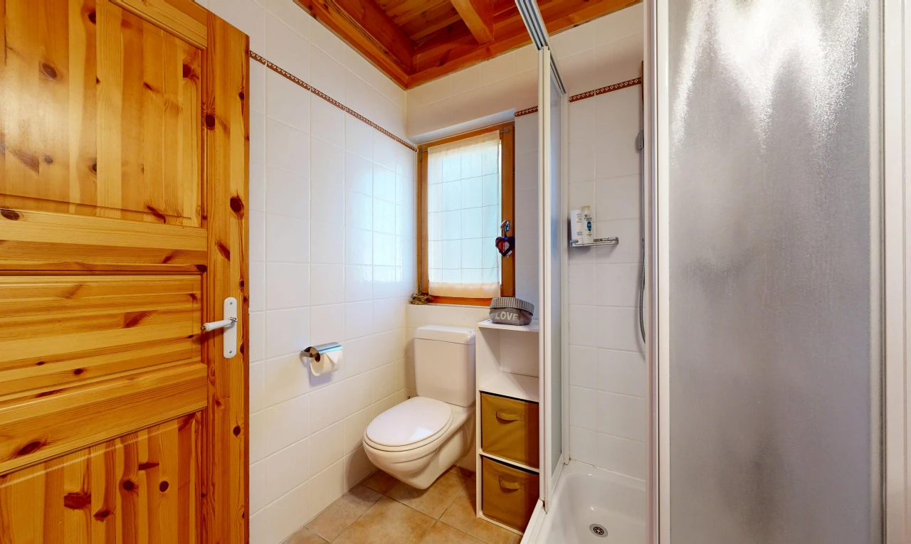 full bathroom featuring a stall shower, light tile patterned floors, and tile walls