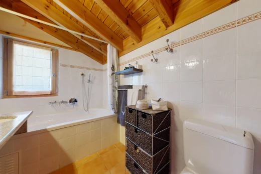 bathroom with tile walls, light tile patterned floors, wooden ceiling, tiled shower / bath, and vaulted ceiling with beams