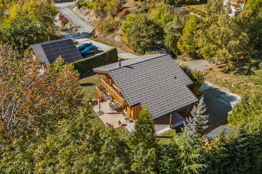 view of home with a patio, solar panels, and view of scattered trees