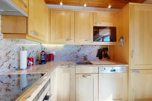 kitchen featuring light wood finish cabinets, black electric cooktop, light stone counters, white dishwasher, and wall oven