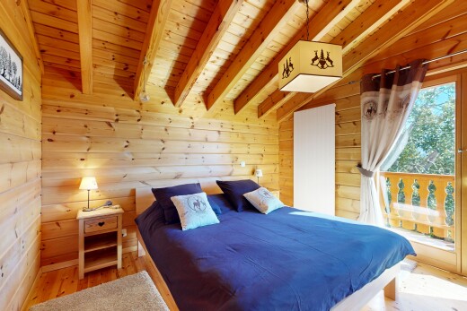 room / bedroom featuring wood ceiling, wood walls, light wood-type flooring, and vaulted ceiling with beams