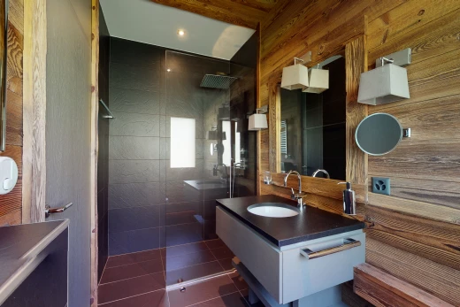salle de bains avec carrelage, lumière naturelle, douche, double vasque, miroir, et meuble-lavabo