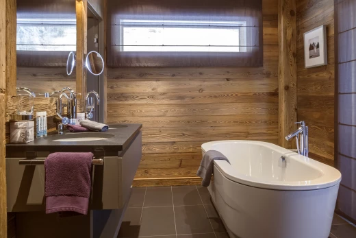 salle de bains avec carrelage, lumière naturelle, baignoire, vasque, et meuble-lavabo