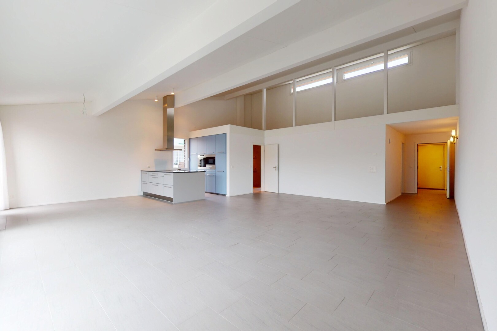 pièce vide avec haut plafond, lumière naturelle, et poutres apparentes