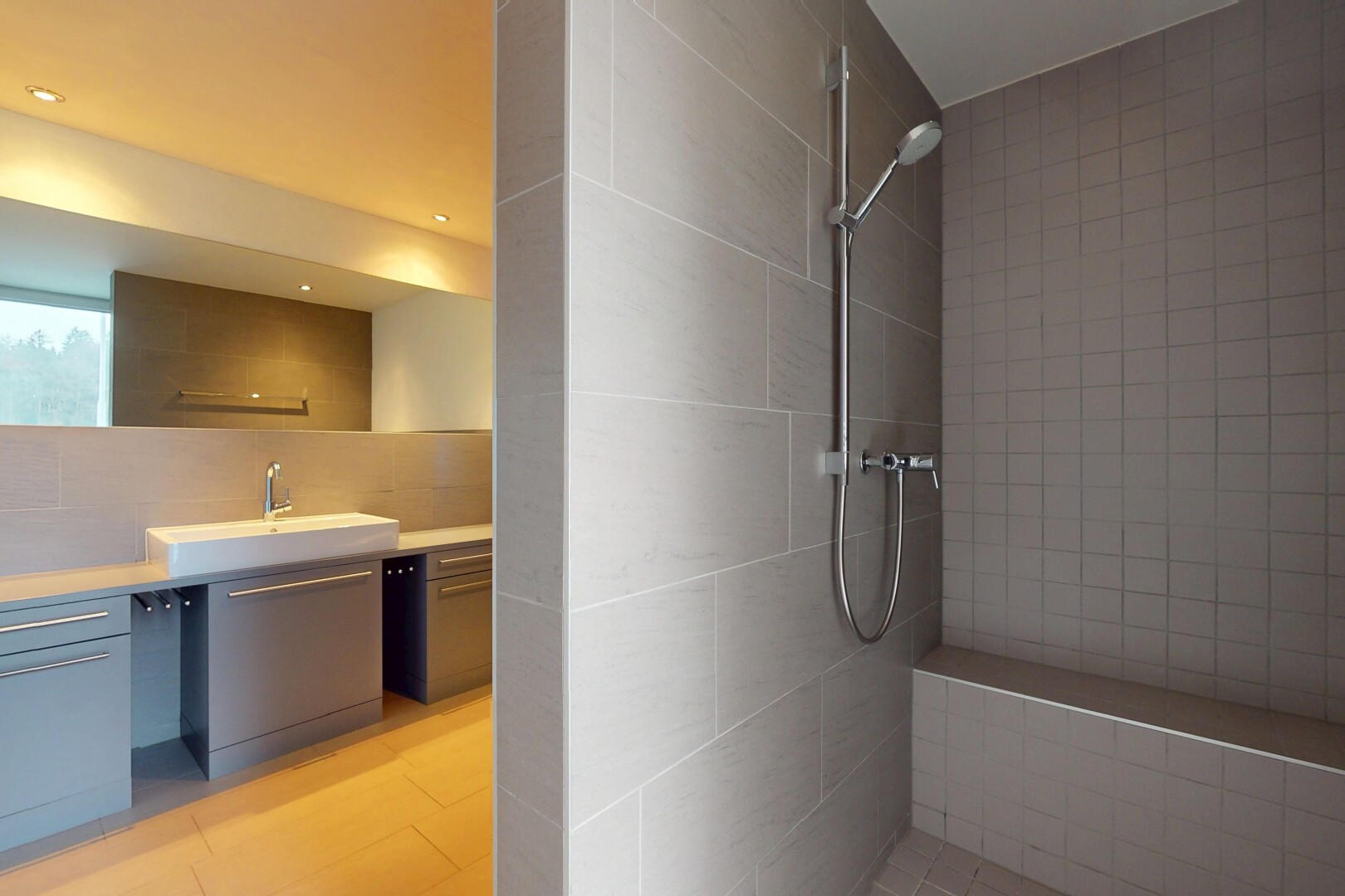 salle de bains avec douche, meuble-lavabo, vasque, miroir, et mur carrelé