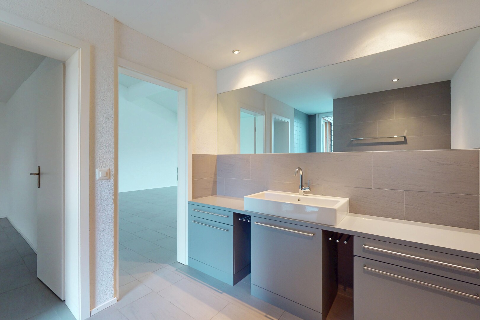 salle de bains avec crédence, vasque, miroir, et meuble-lavabo