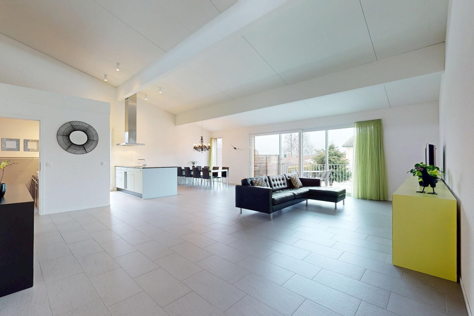 espace intérieur avec poutres apparentes, lustre, lumière naturelle, plafond voûté, et haut plafond