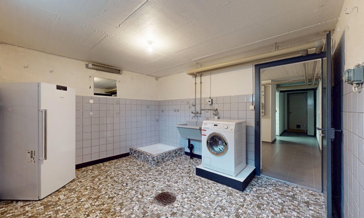 buanderie avec machine à laver / sèche-linge, vasque, buanderie, carrelage, et mur carrelé