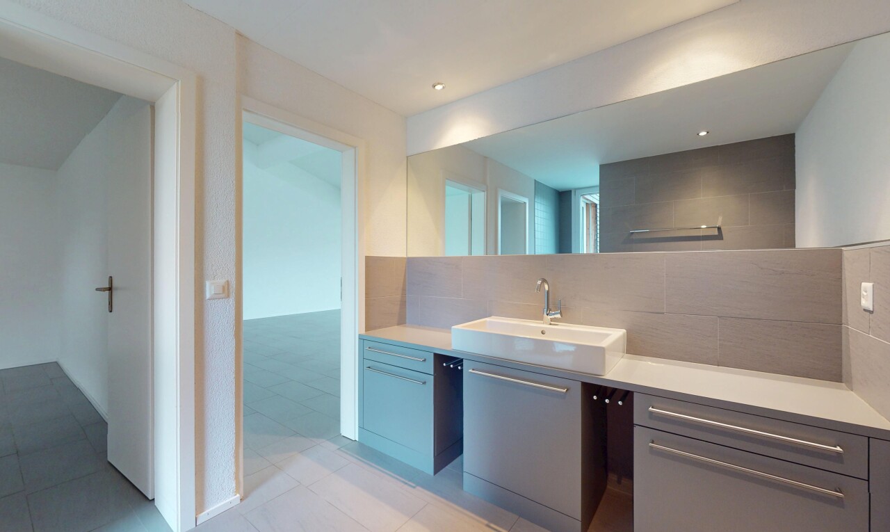 salle de bains avec crédence, vasque, miroir, et meuble-lavabo