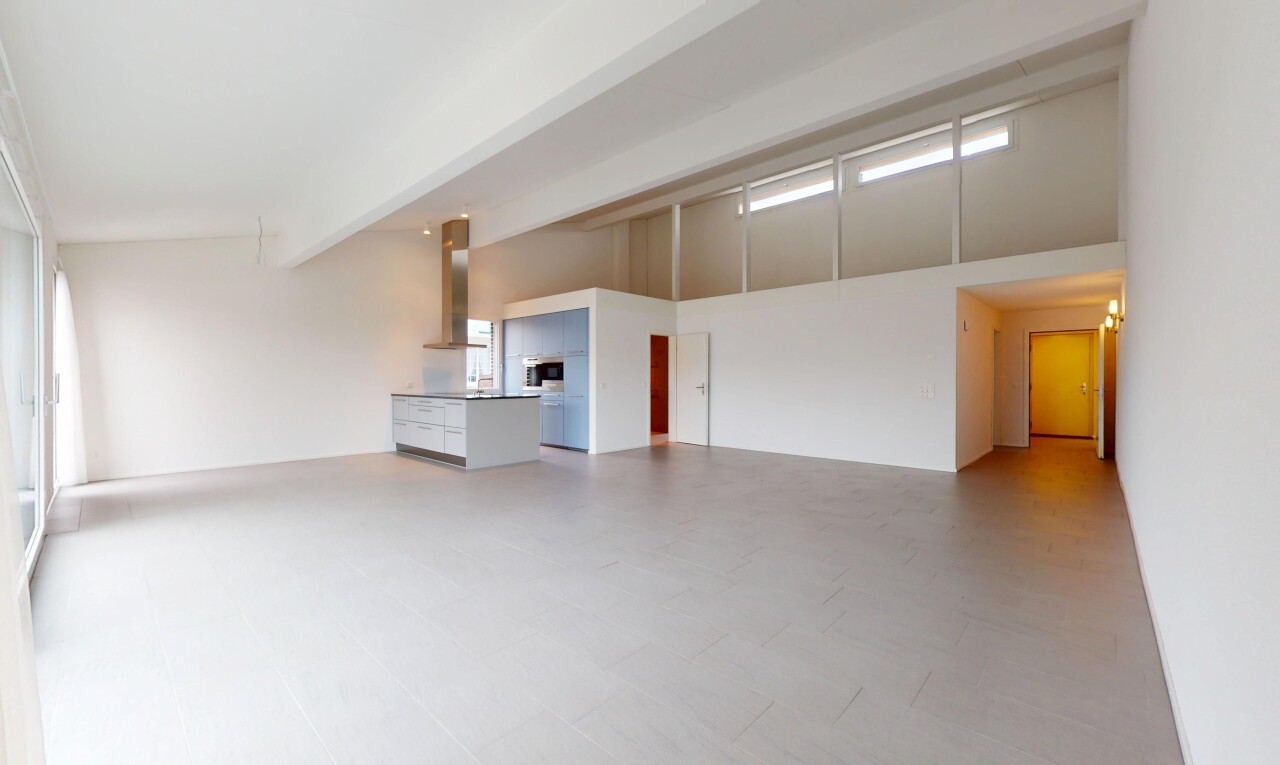 pièce vide avec haut plafond, lumière naturelle, et poutres apparentes
