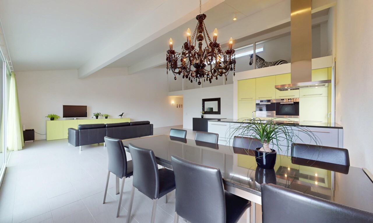 salle à manger avec télévision et poutres apparentes