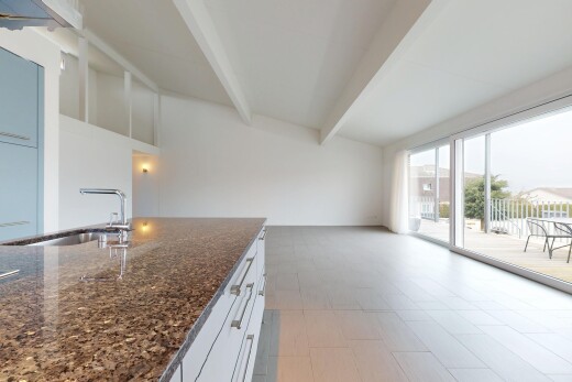 kitchen with sink, white cabinetry, beamed ceiling, and dark stone countertops