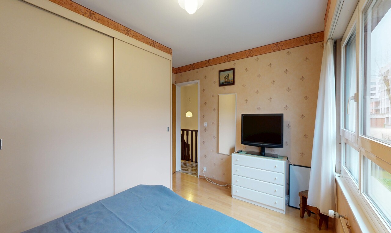 zimmer / schlafzimmer mit wallpaper wall, tapetenwand, fernseher, inside property, und wood finish floor