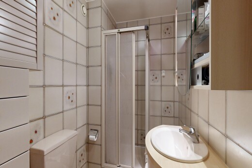 full bathroom with a stall shower, tile walls, and vanity