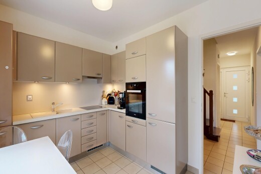 kitchen featuring black appliances, light countertops, light tile patterned floors, and cream cabinets