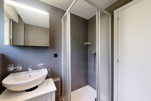 salle de bains avec inside property, tile shower, miroir, lavabo (ou coiffeuse selon le contexte), et douche
