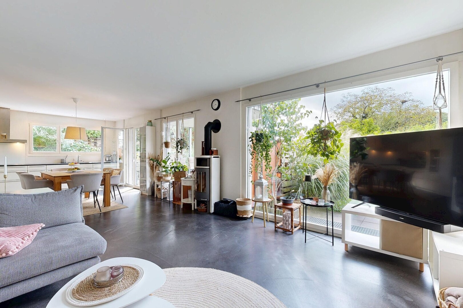 salon / salle à manger avec télévision, inside property, poêle à bois, lumière naturelle, et natural light
