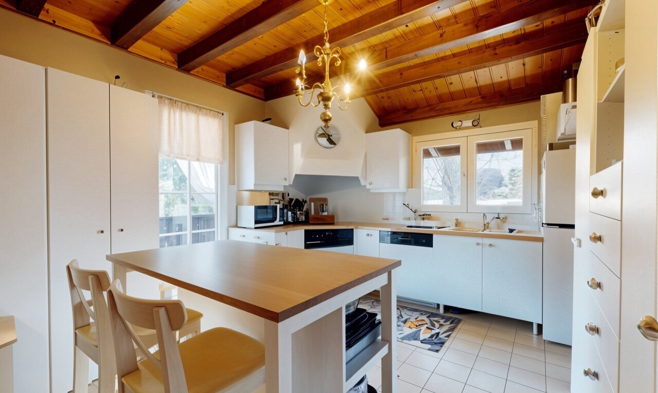 cuisine avec plafond de bois, suspension, réfrigérateur, lave-vaisselle, et meubles blancs