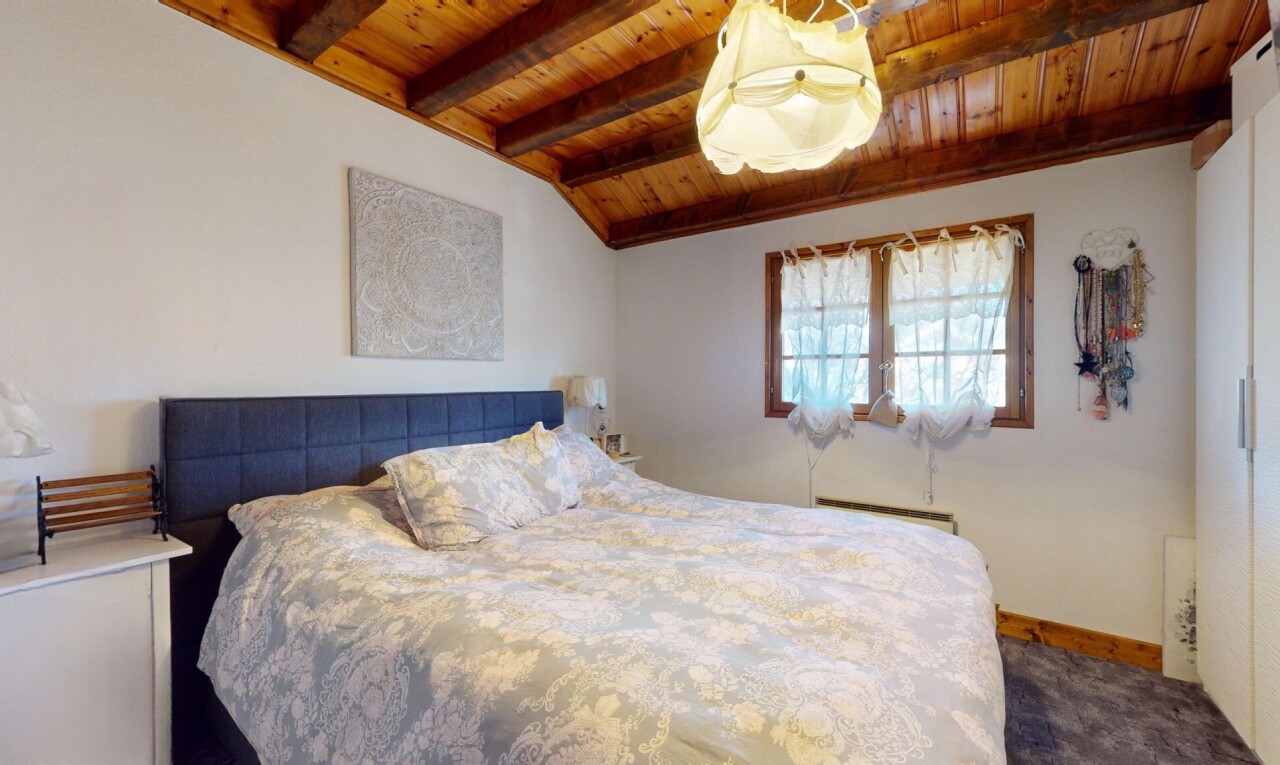 chambre avec plafond voûté, moquette, plafond de bois, lumière naturelle, et poutres apparentes