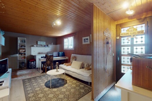 salon / salle à manger avec mur en bois, plafond en bois, télévision, et lumière naturelle