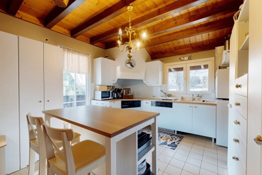 cuisine avec plafond de bois, suspension, réfrigérateur, lave-vaisselle, et meubles blancs