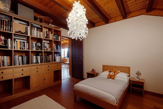 chambre avec sol en finition bois, plafond en bois, lustre remarquable, et cloison sèche