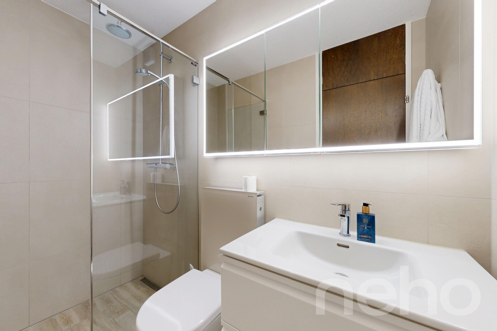 full bath featuring a walk in shower, vanity, and light wood finished floors