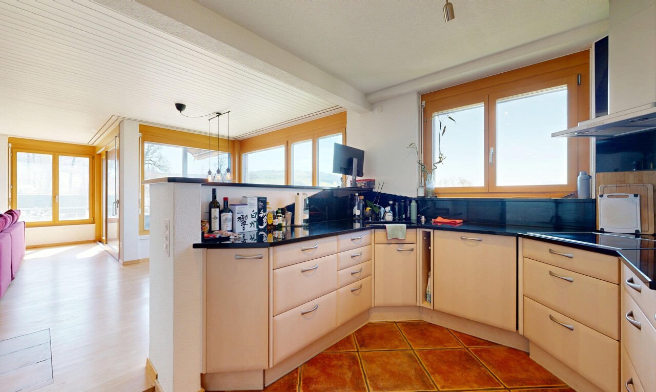 kitchen with a peninsula, dark countertops, hanging light fixtures, and light tile patterned floors