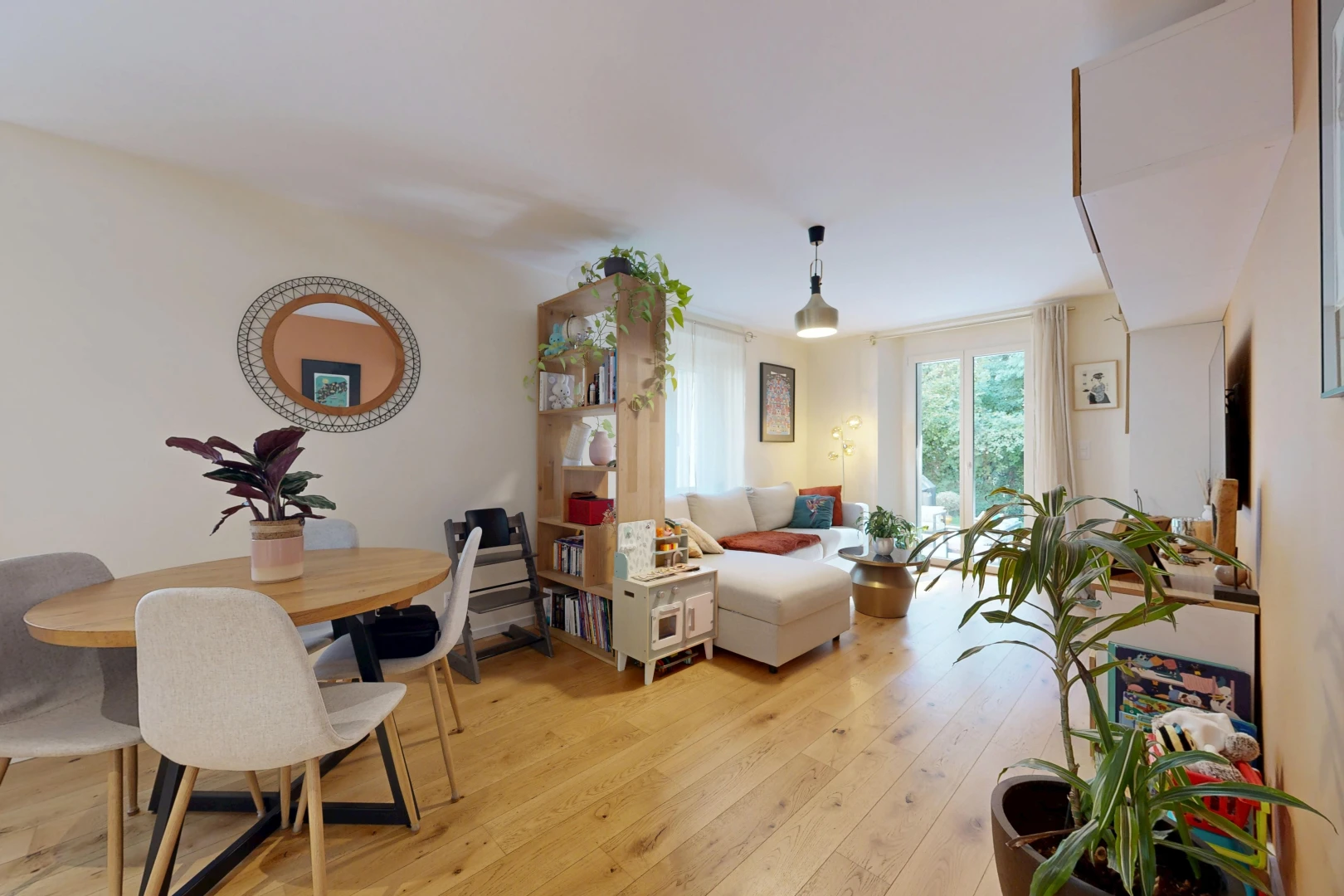 wohn- / esszimmer mit pendelleuchte, gipskartonwand, drywall, holzfußboden, und wood finish floor