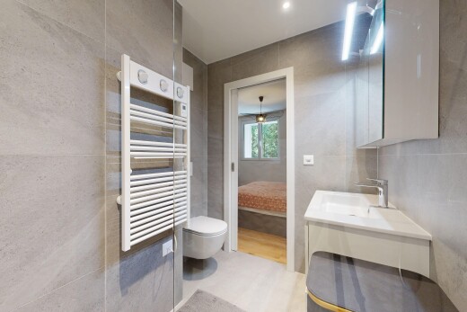 salle de bains avec tile wall, mur en carrelage, miroir, radiateur, et lavabo (ou coiffeuse selon le contexte)