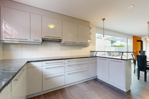 küche mit natürliches licht, küchentheke, küchenrückwand beim herd, pendelleuchte, und parkettboden