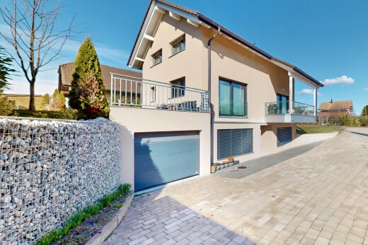 außenansicht mit balkon, eingebaute garage, stuckverkleidung, und auffahrt