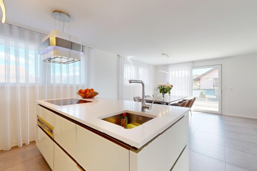 küche mit herd, natürliches licht, pendelleuchte, waschbecken, und weiße schränke