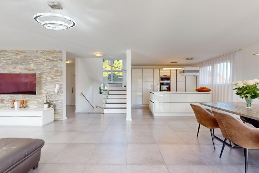 wohn- / esszimmer mit fliesenboden, natürliches licht, steinwand, und treppen