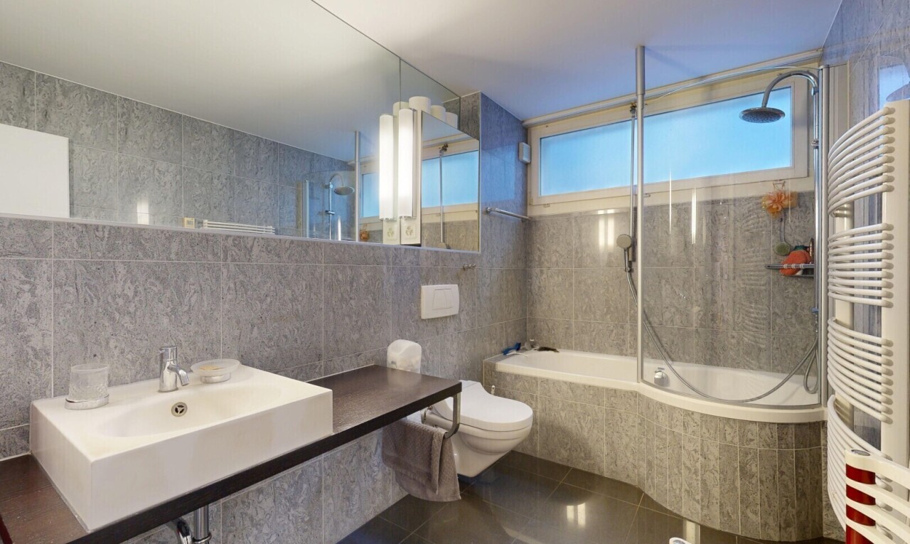 full bath with tile walls, tiled shower / bath, radiator heating unit, dark tile patterned floors, and vanity