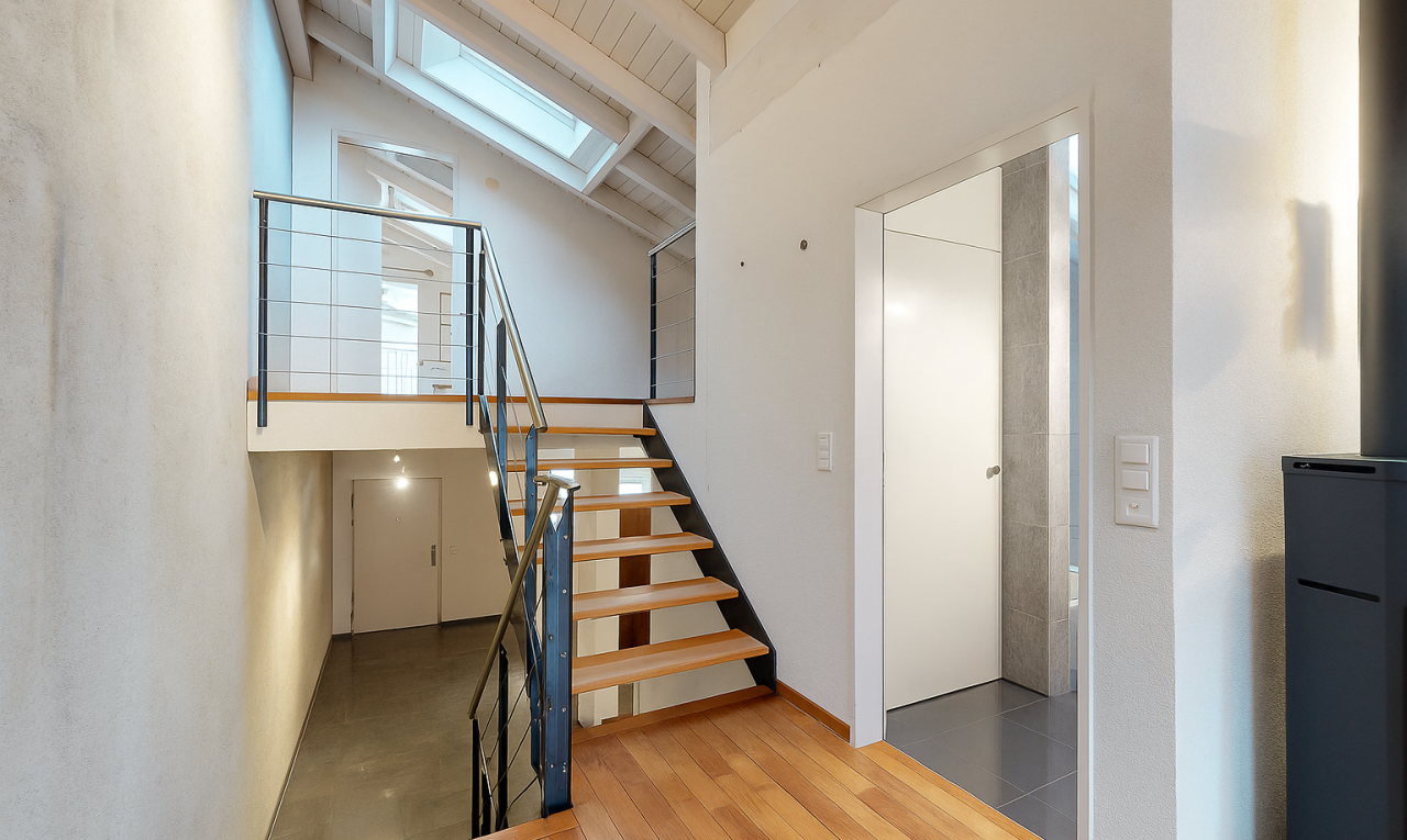 stairway featuring a skylight, wood finished floors, a wood ceiling with exposed beams, and a towering ceiling