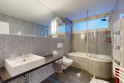 salle de bains avec mur en carrelage, tile wall, douche-bain combinés, radiateur, et salle de bain complète