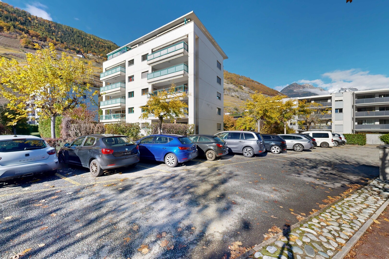 view of apartment building / complex with a mountain view and uncovered parking
