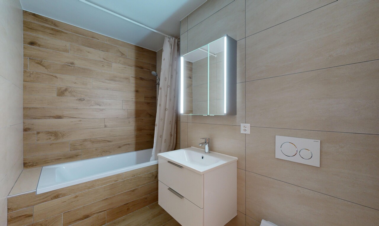 full bathroom featuring tiled shower / bath, vanity, and tile walls