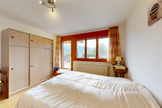 chambre avec radiateur, placard, inside property, sol en finition bois, et wood finish floor