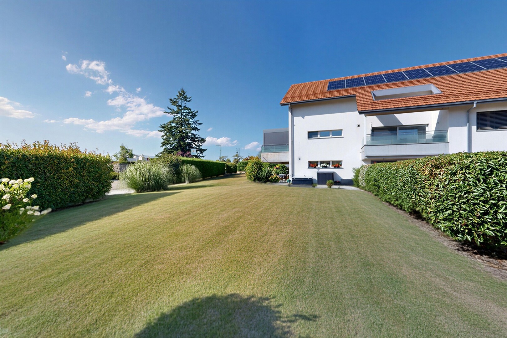 façade avec toit en tuiles, pelouse, day time, property visible, et panneaux solaires