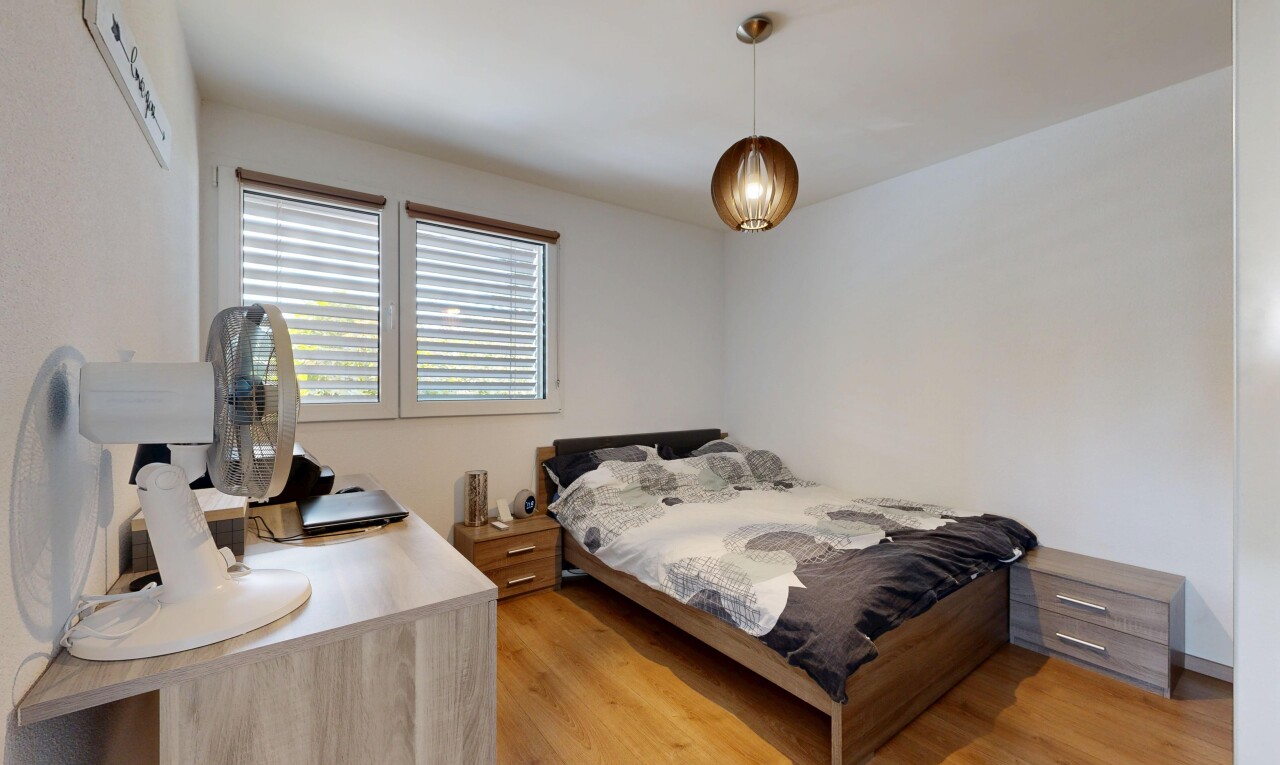 chambre avec éclairage suspendu, cloison sèche, drywall, sol en finition bois, et wood finish floor