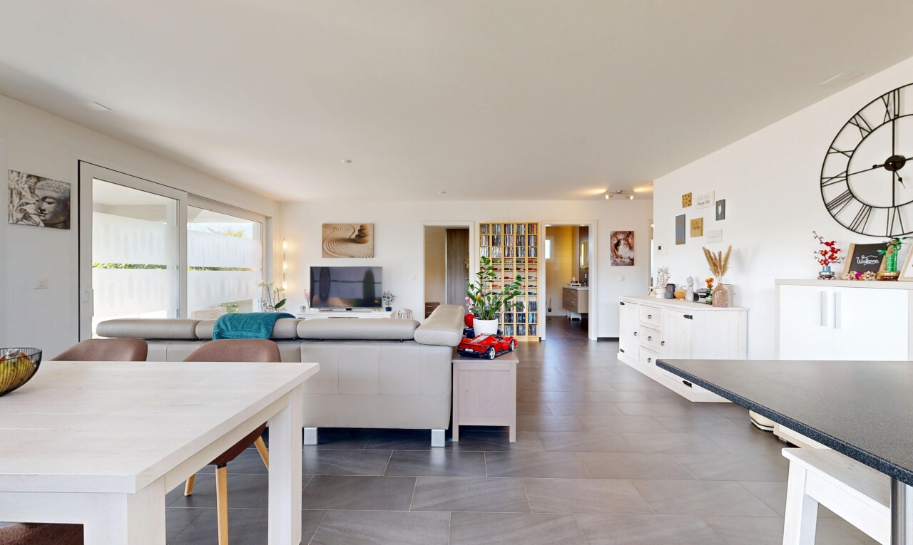 salon / salle à manger avec éclairage sur rail, drywall, cloison sèche, et télévision