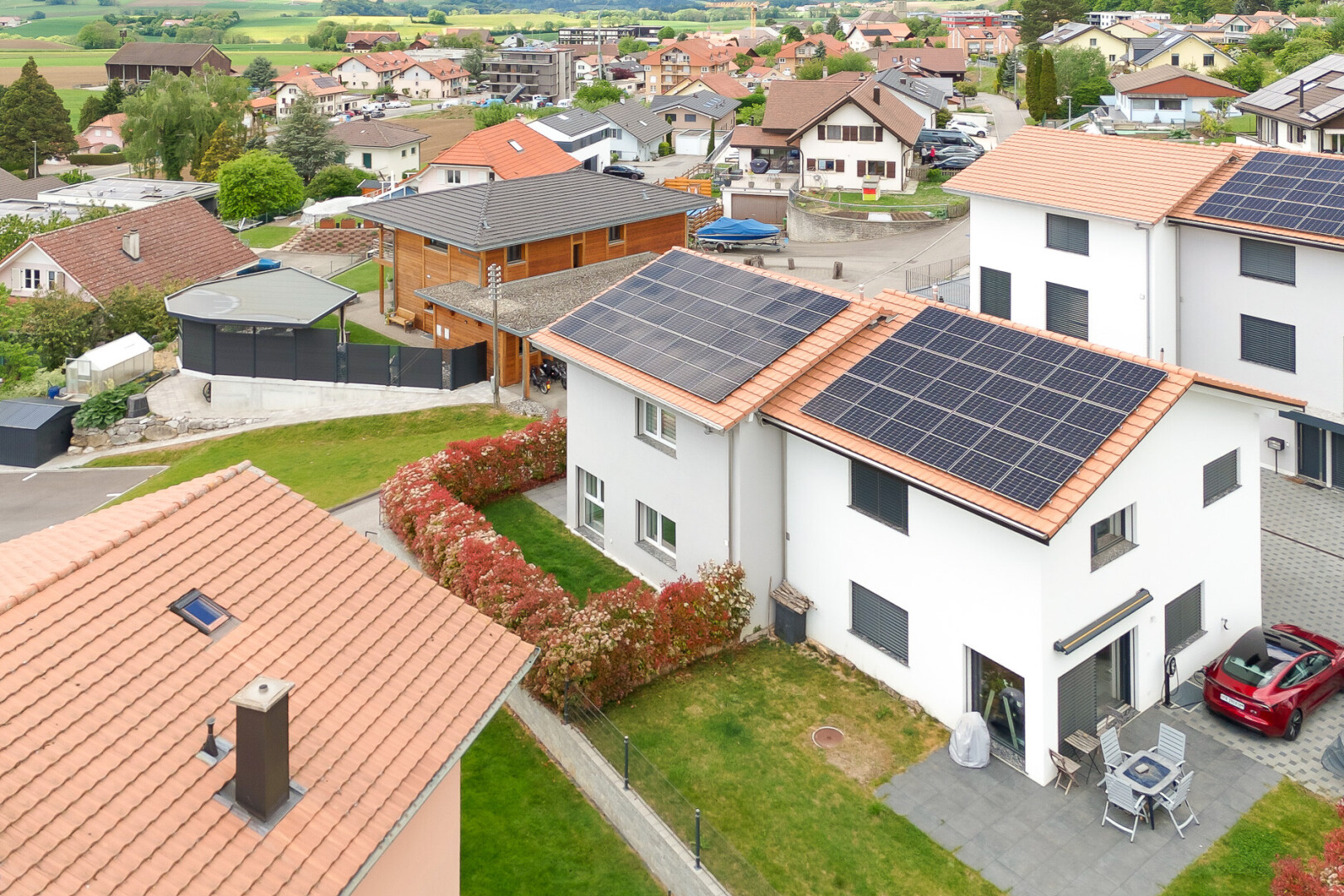 outdoor house with stucco siding, roof mounted solar panels, a patio, and a residential view