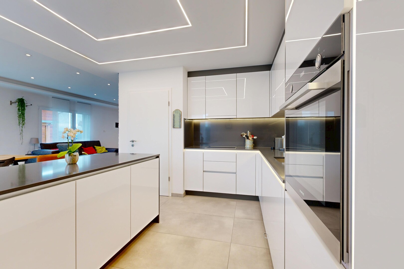 kitchen with modern cabinets, white cabinetry, oven, and backsplash